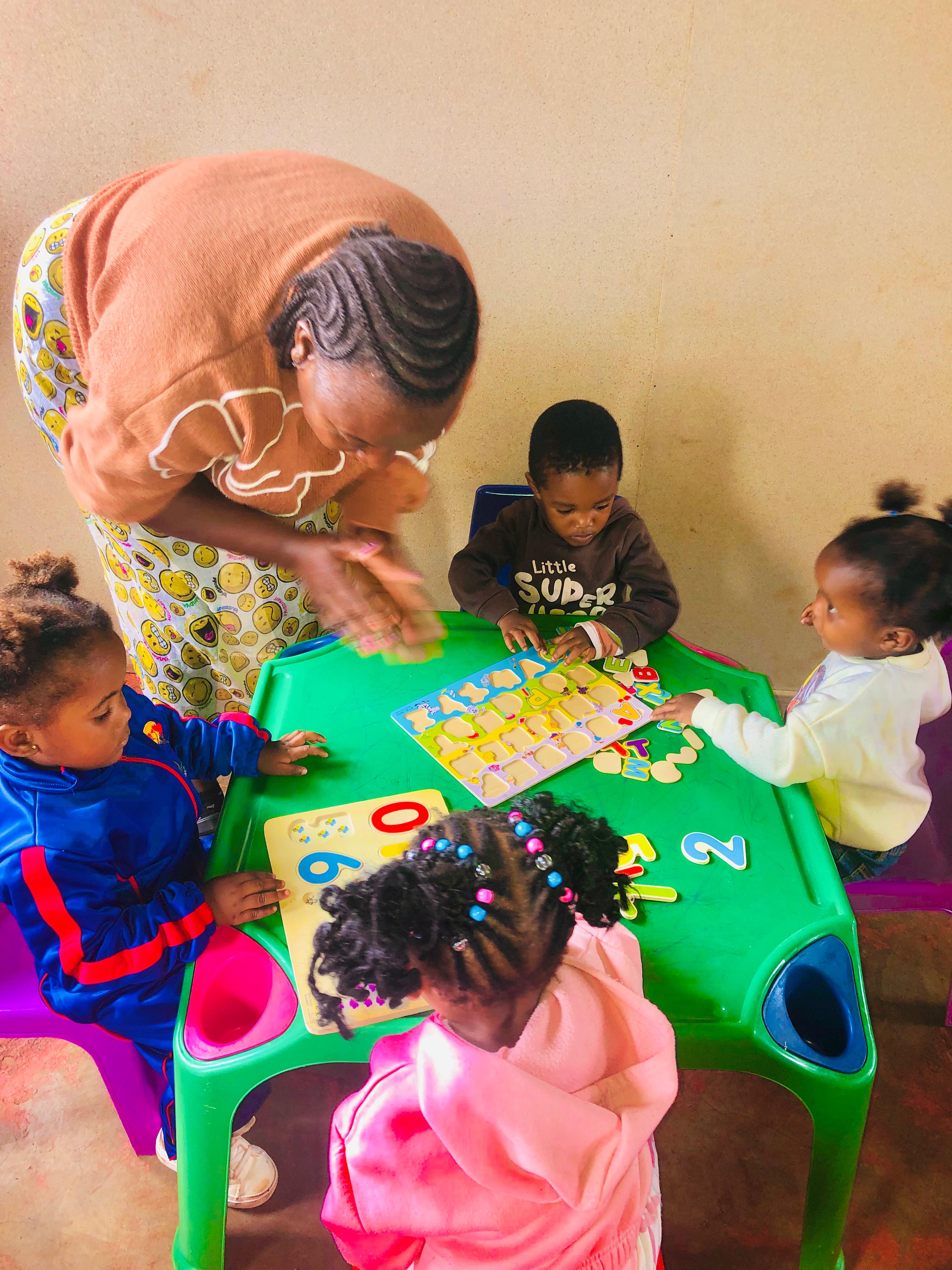 A teacher guiding children through a classroom activity