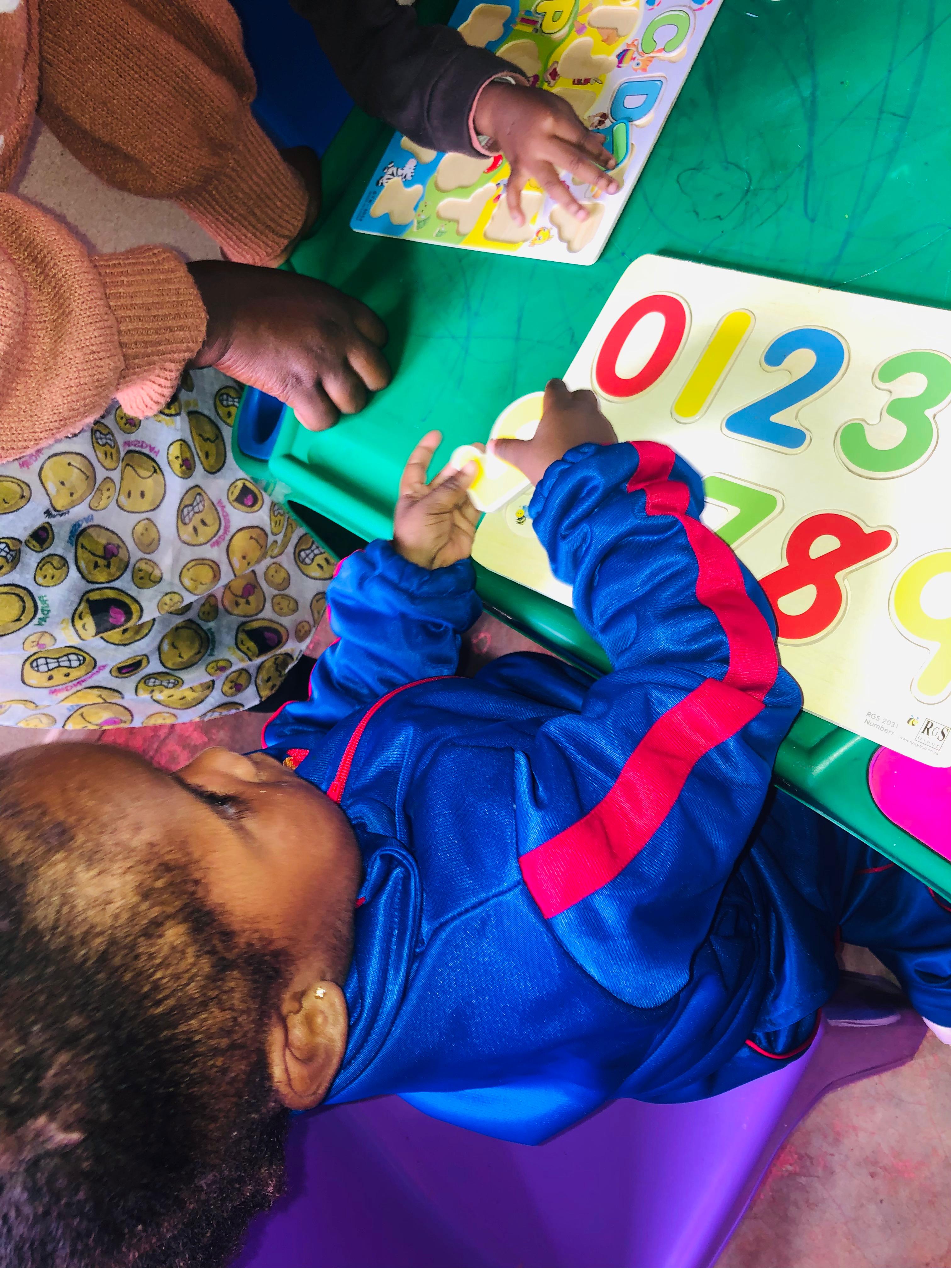 Children sharing an activity at Restoration Day Care Centre